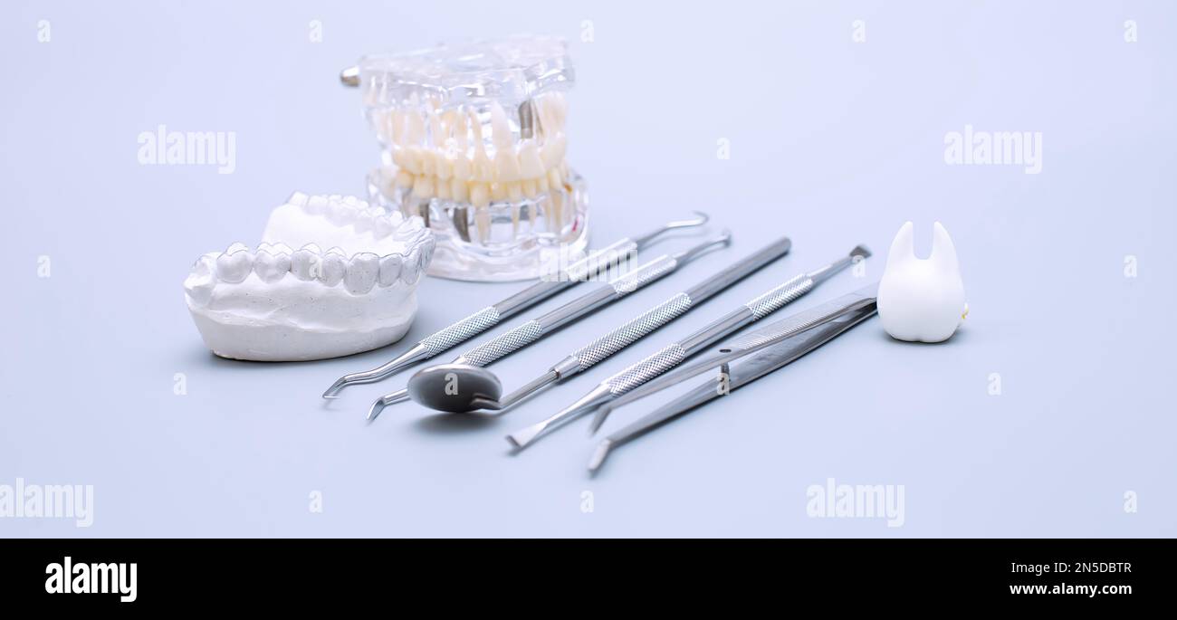 Dental tools and model of teeth on a blue background. Dental care ...