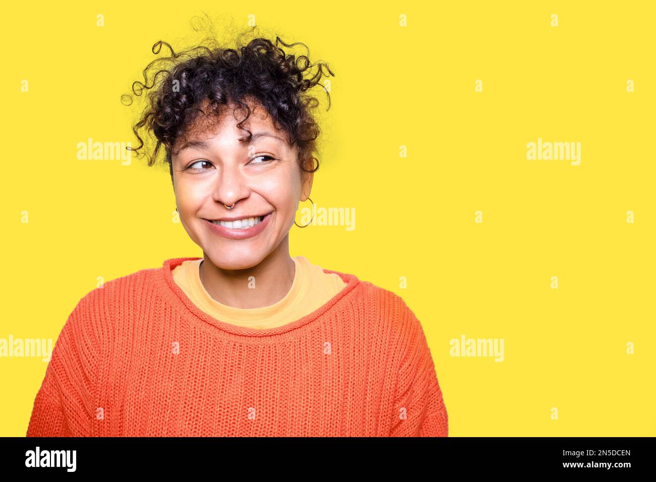 Clever black woman face expression isolated on yellow background Stock
