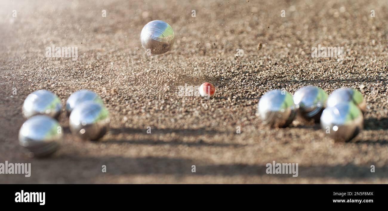 Petanque ball boules bowls on a dust floor, photo in impact. Game of