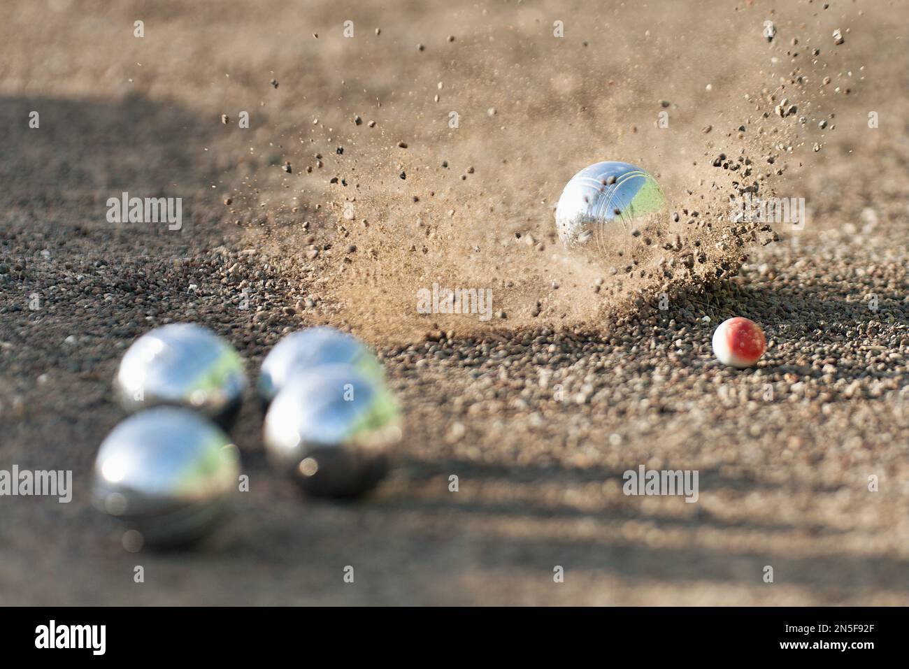 Petanque ball boules bowls on a dust floor, photo in impact. Game of