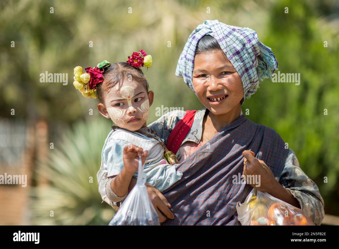 Burmese betel chewing woman with child in Bagan. Facial painting with ...