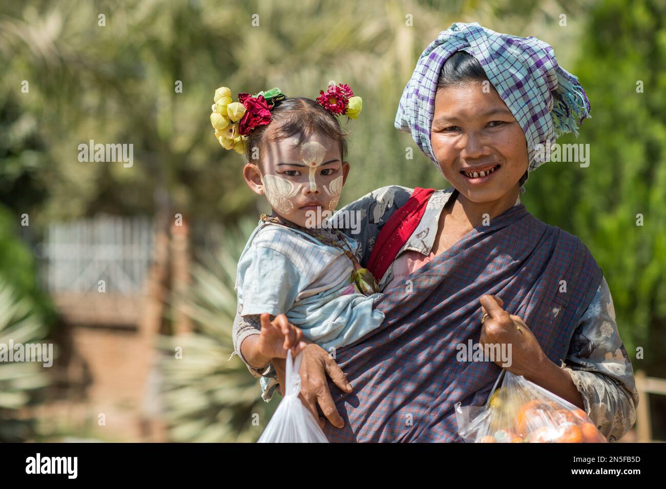 Burmese betel chewing woman with child in Bagan. Facial painting with ...