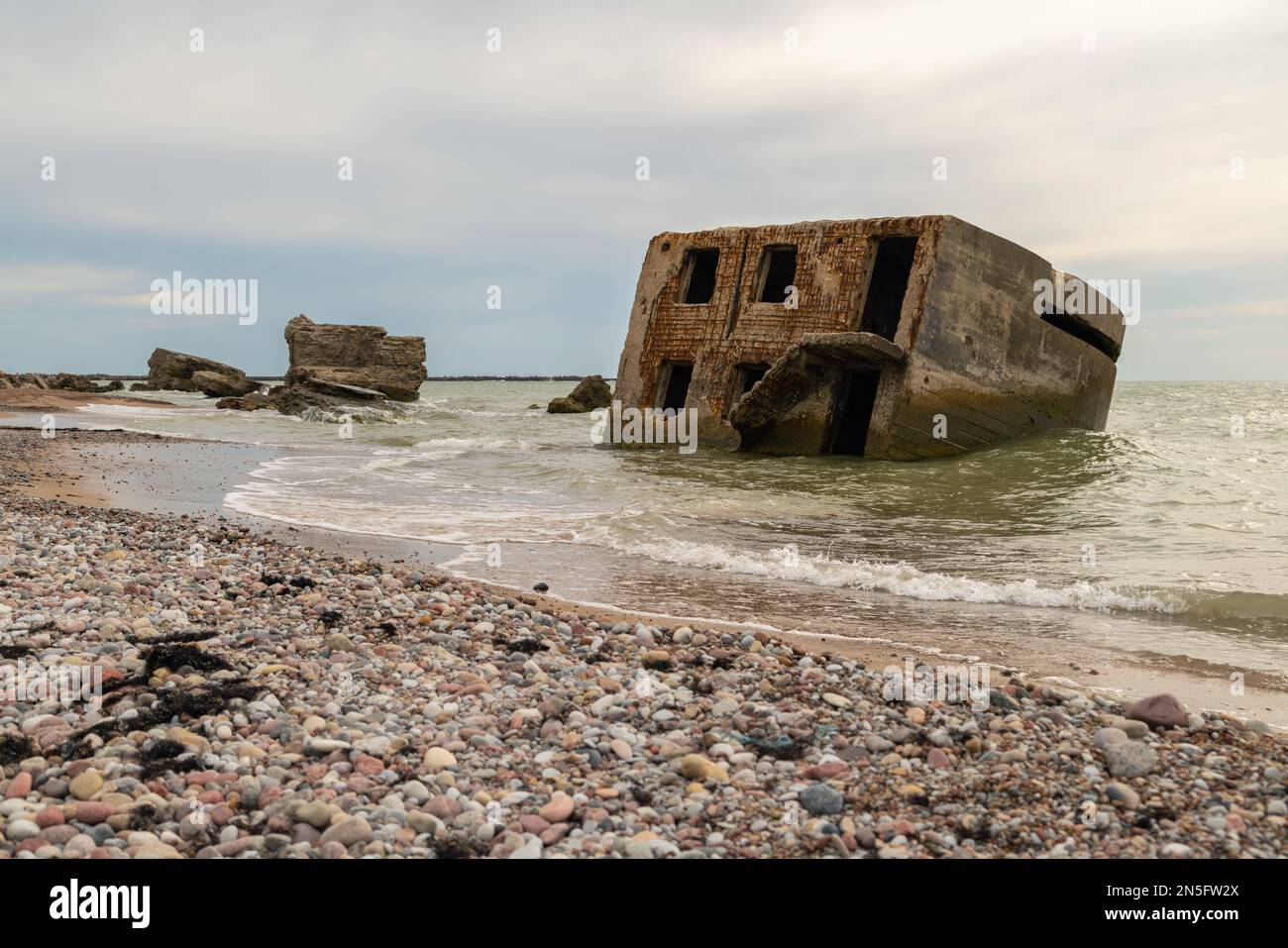 Abandoned buildings on the seashore in the water. War ruins decomposing ...