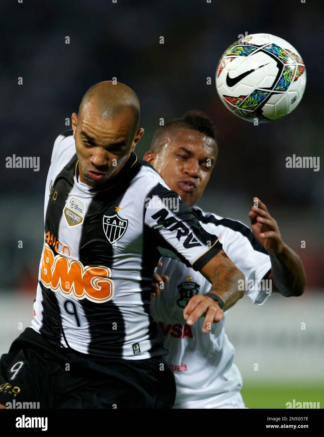 Diego Tardelli of Brazil's Atletico Mineiro, left, heads the ball with