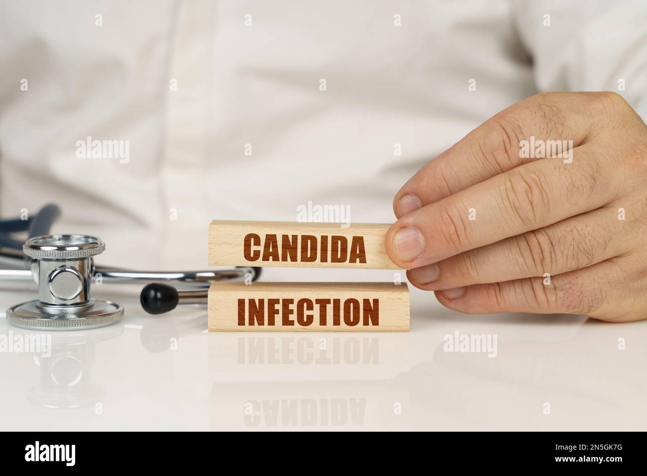Medical concept. On a white surface, a stethoscope and wooden plates with the inscription - Candida infection Stock Photo