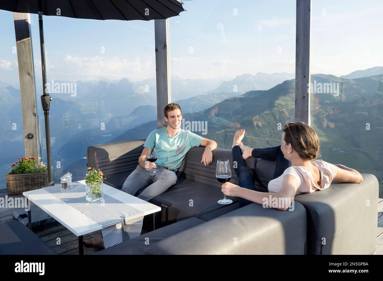 Young couple drinking wines on terrace, Zillertal, Tyrol, Austria Stock Photo