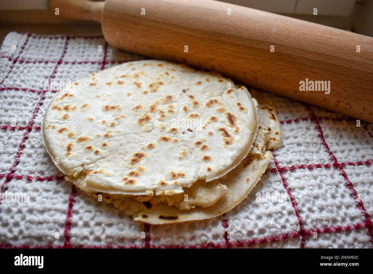 Stack of thin flatbread lavash on a wooden serving board Stock Photo