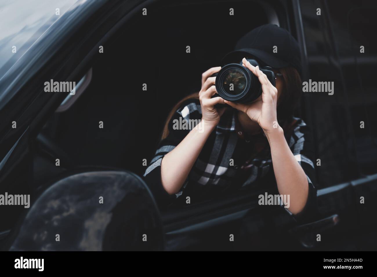 Private detective with camera spying from car Stock Photo