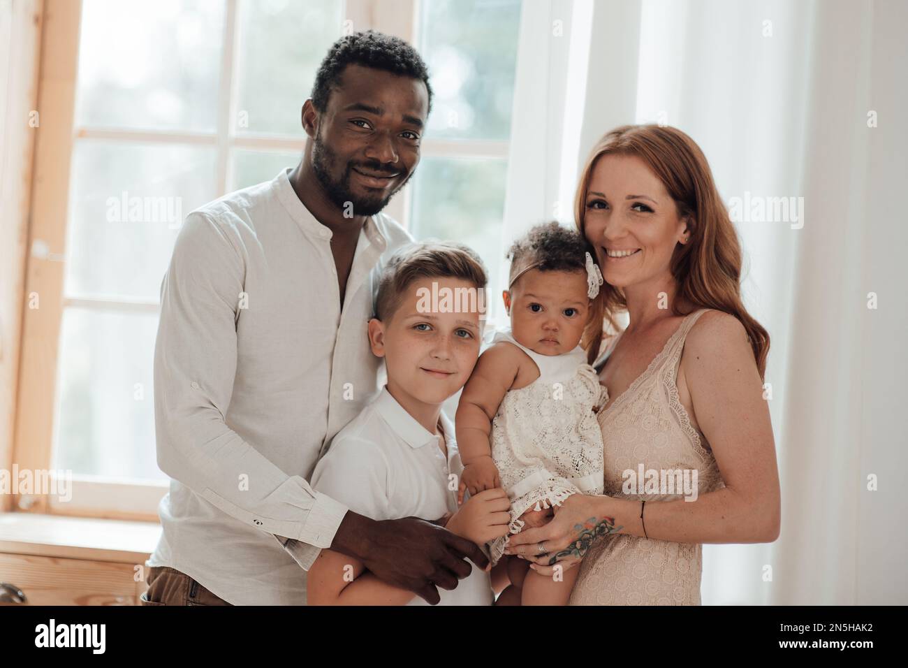 Mixed race family with white son and infant swarthy daughter spend time