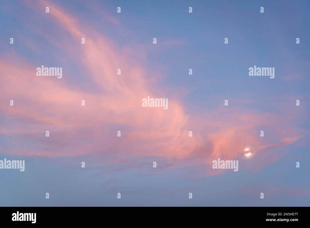 Pink cloudscape with the Moon Stock Photo