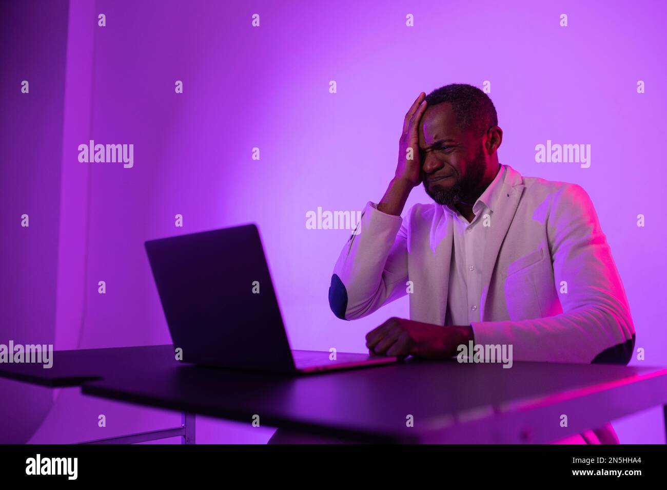 angry man at work. angry african american worker looking at laptop screen with software problems. Stock Photo