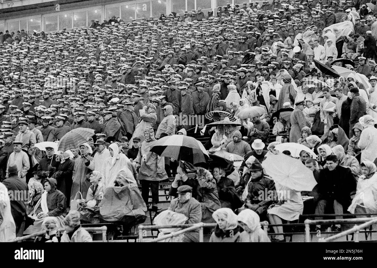 While other spectators huddle under umbrellas and rain gear