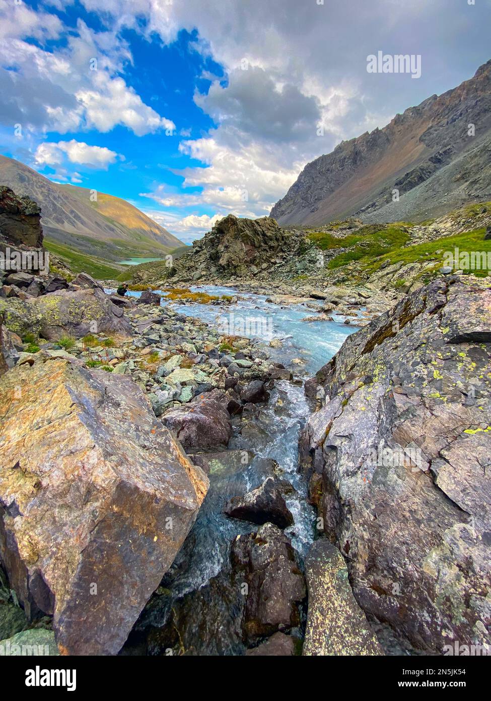 The river flows among the stones during the day in the Altai mountains. Stock Photo