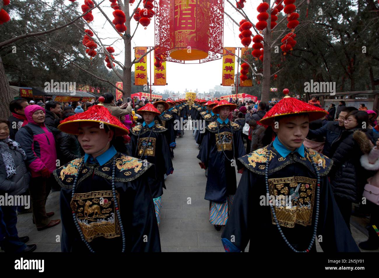 Men dressed as a Qing Dynasty emperor, center in the background, and ...