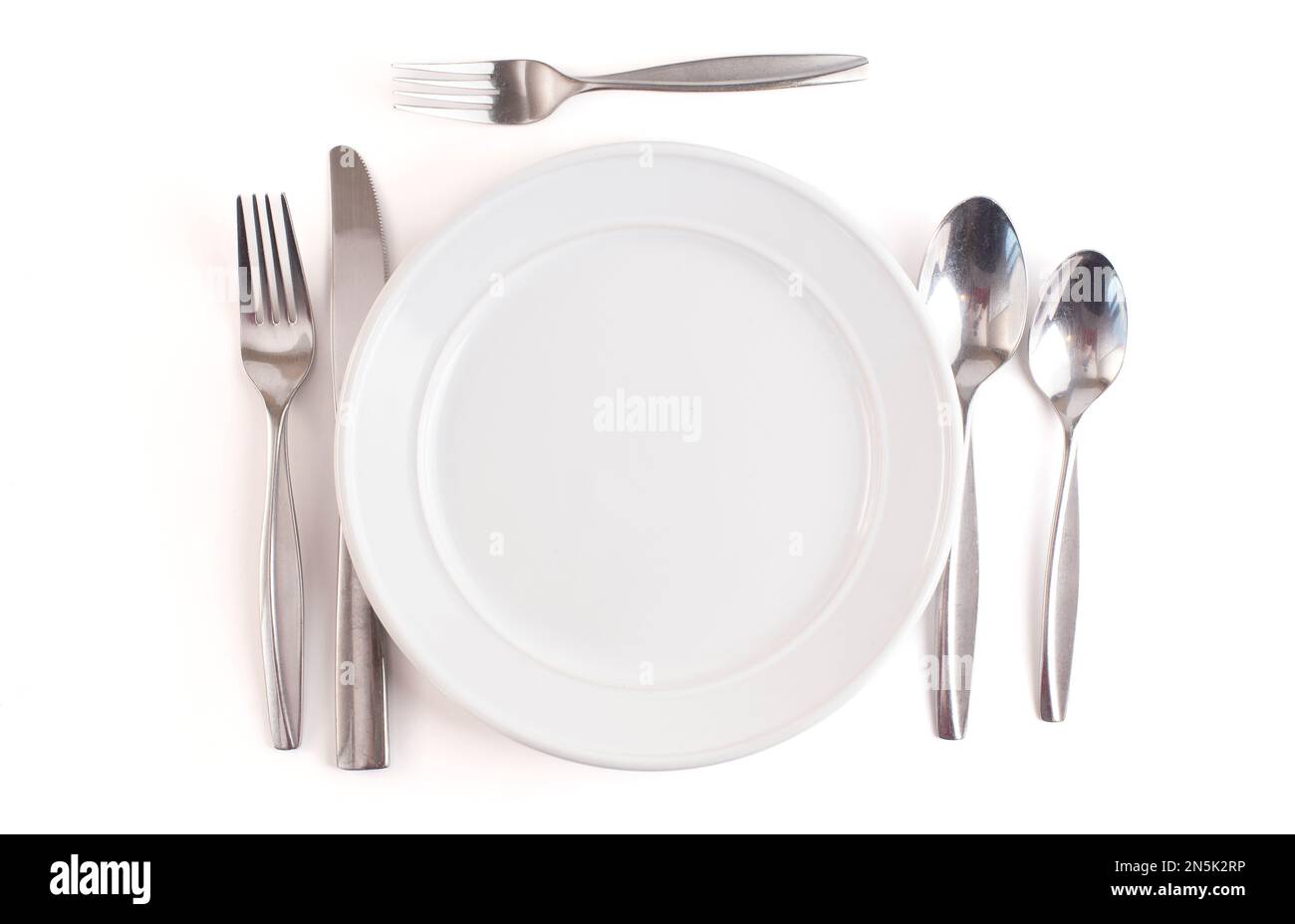 Table Set with a Clean and Emtpy White Set of Dishes and Silverware