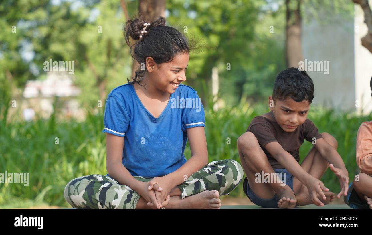 Indian little girl and a boy doing meditate yoga asana on roll mat with ...