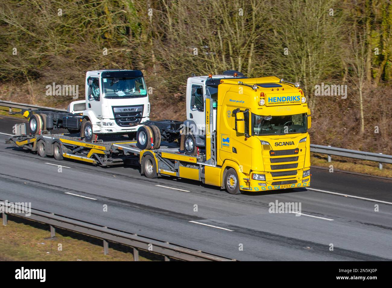 HENDRICKS International Car Transporter SCANIA 590 S towing ROLFO trailer carrying New DAF LF tractor units; travelling on the M61 motorway UK Stock Photo