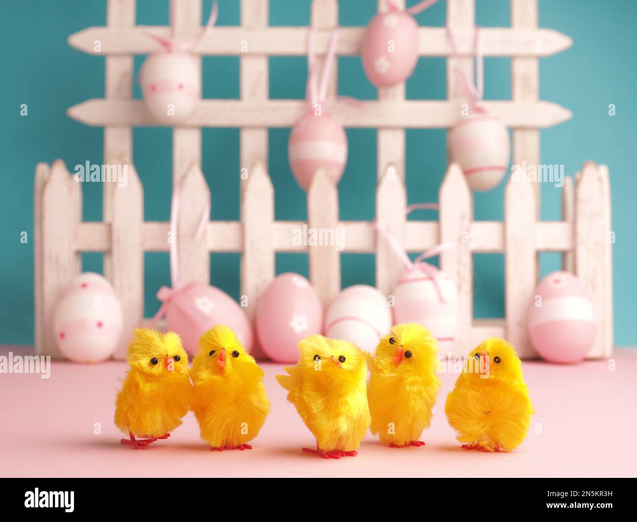 Close up of five cute chicks with Easter eggs background Stock Photo