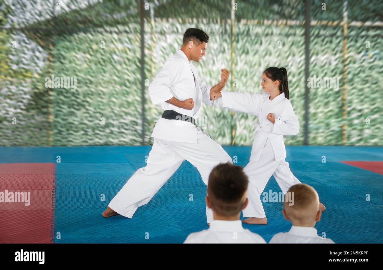 Girl practicing karate with coach on tatami outdoors Stock Photo