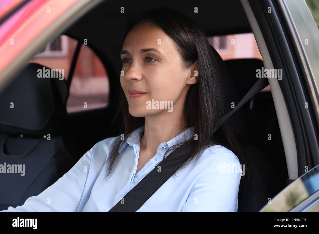 Woman with fastened safety belt on driver's seat in car Stock Photo Alamy