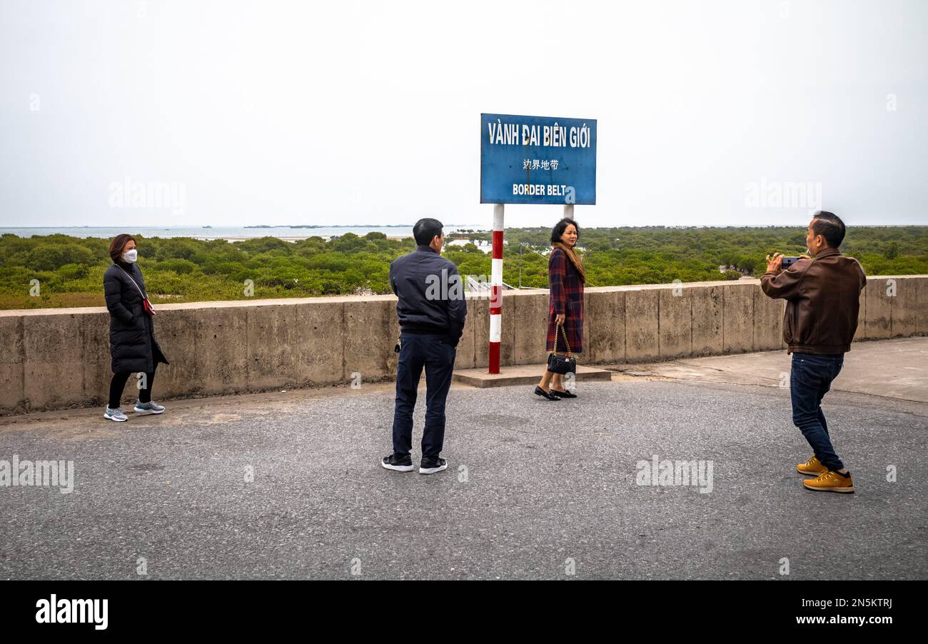 Four Vietnamese domestic tourists at Vietnam's easternmost point near the border with China at Trang Vi near Mong Cai, Vietnam. Stock Photo