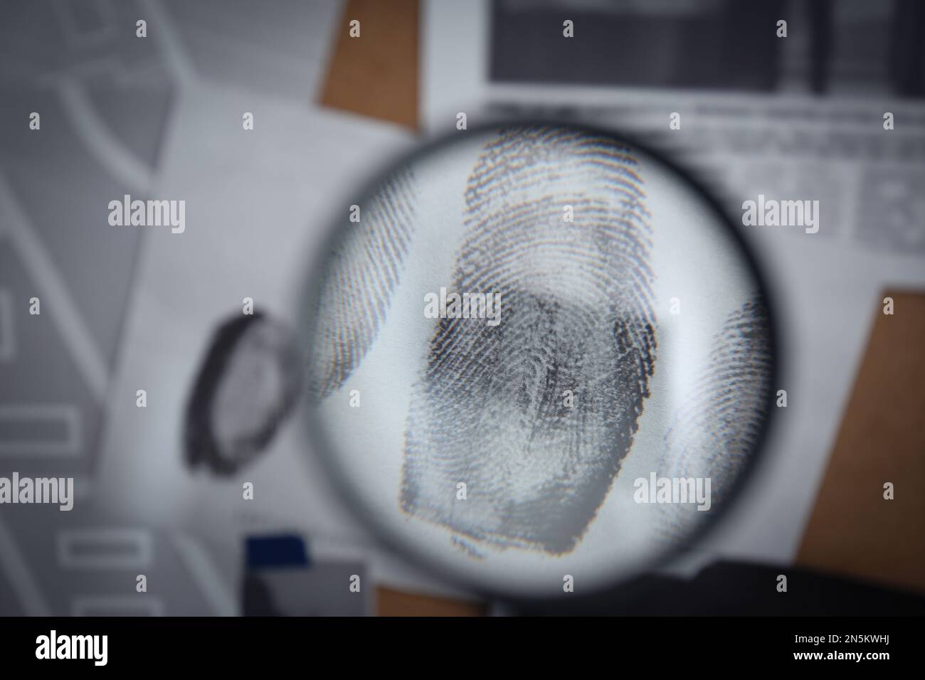 Looking through magnifying glass at fingerprints on detective board ...