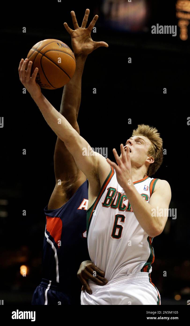 Milwaukee Bucks' Nate Wolters, right, puts up a shot against the