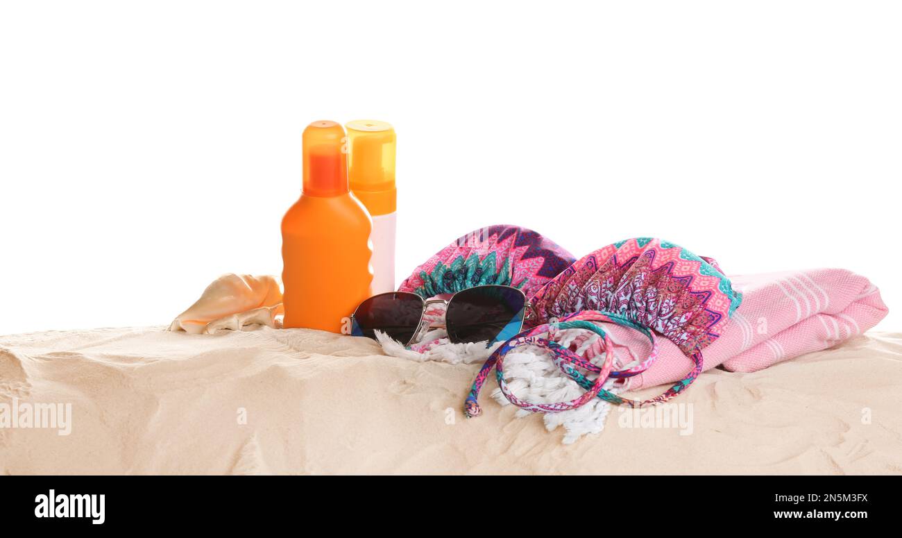 Different beach accessories on sand against white background Stock Photo
