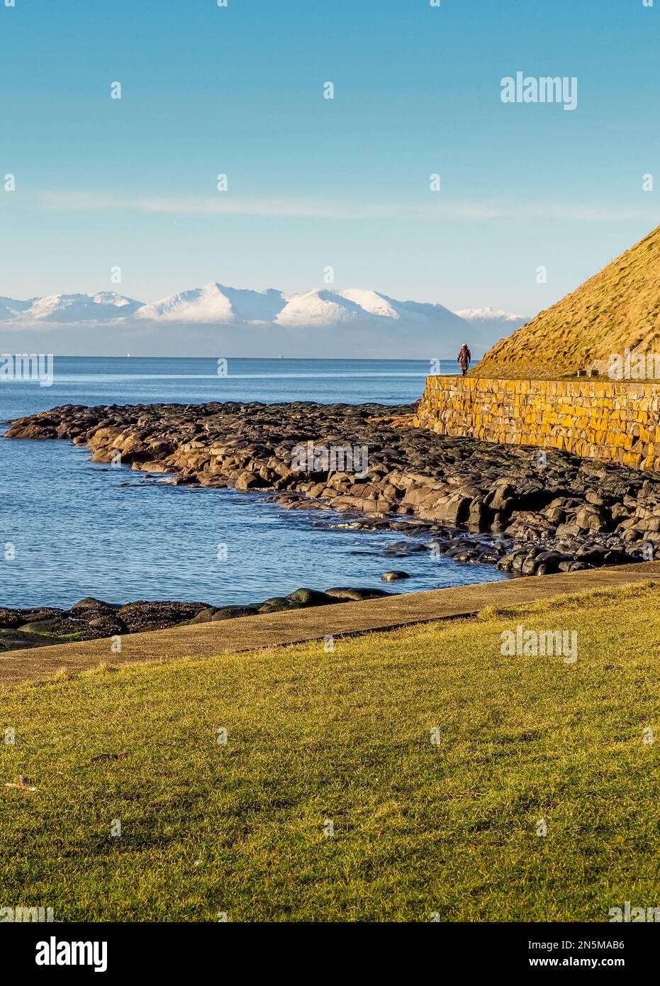 View looking across the Firth of Clyde to the snow-capped peaks of the island Arran from the sea front at Troon Stock Photo