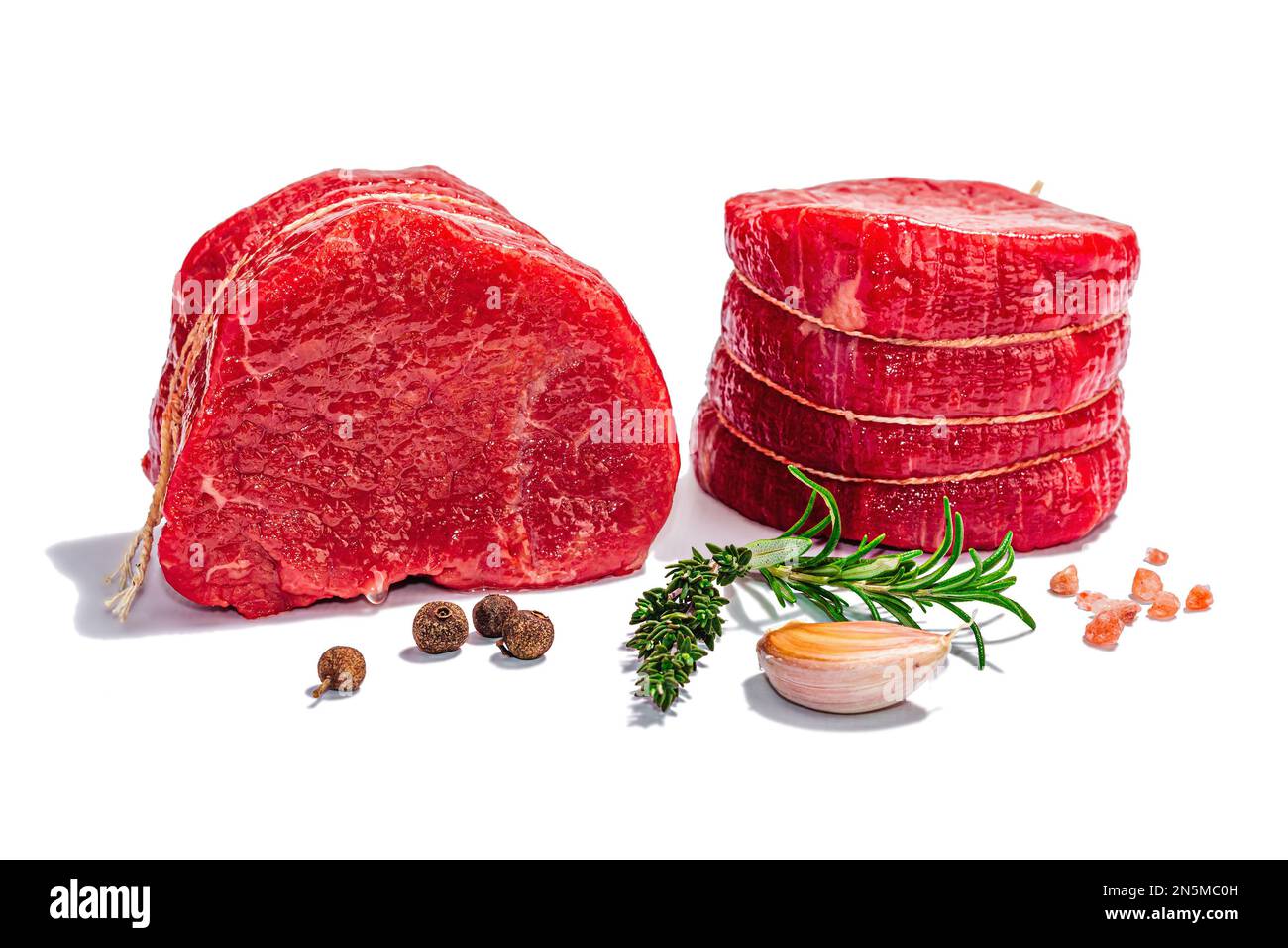 Raw Eye of round steak with spices and herbs isolated on white