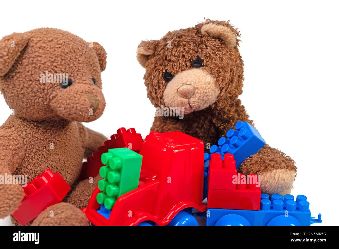 Plush bears and plastic building blocks against a white background Stock Photo