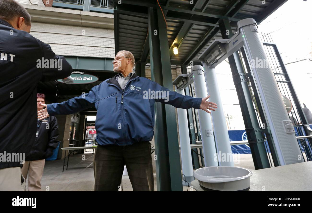 Seattle Mariners employee Chuck Viltz stands as he is checked with a