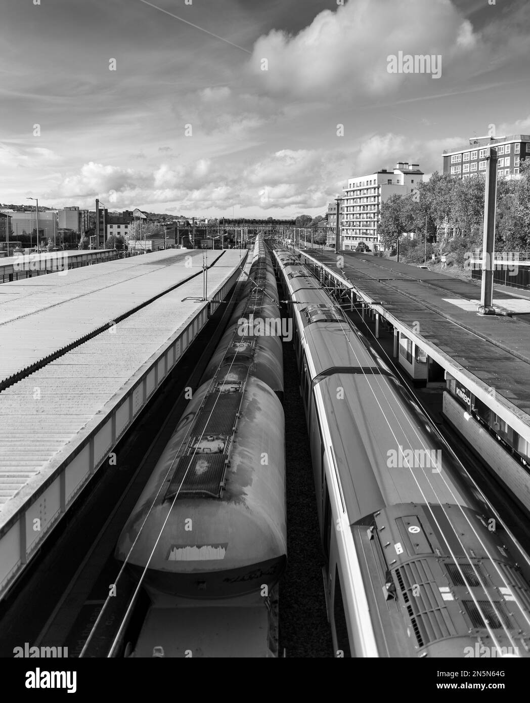 A vertical grayscale shot of the trains moving through the city Stock