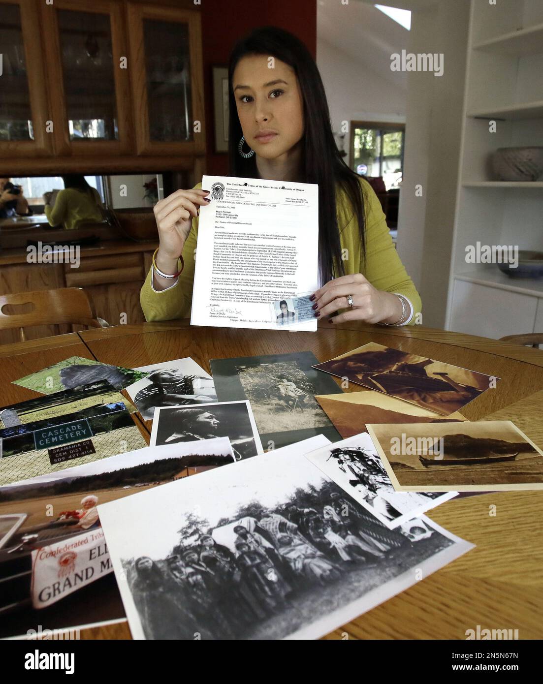 Mia Prickett sits at a table with a collection of family photos and