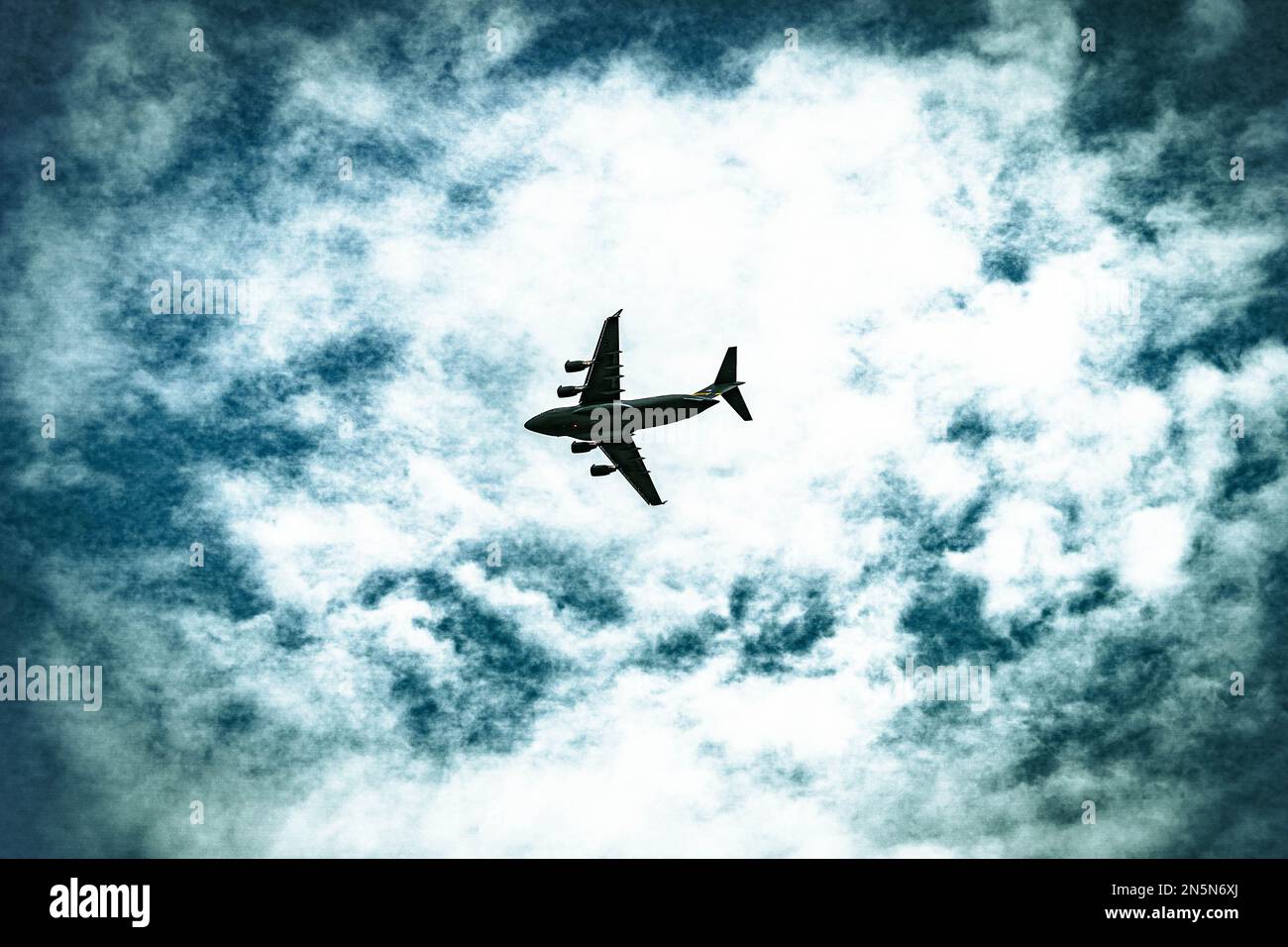 A low angle of an airplane flying in the cloudy sky Stock Photo - Alamy