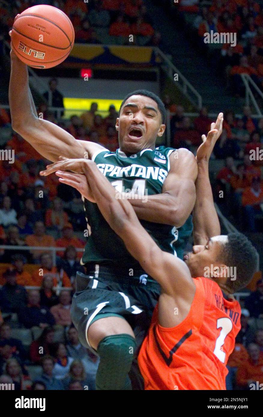 Michigan State guard Gary Harris (14) goes up over Illinois' Joseph Bertrand (2) during an NCAA