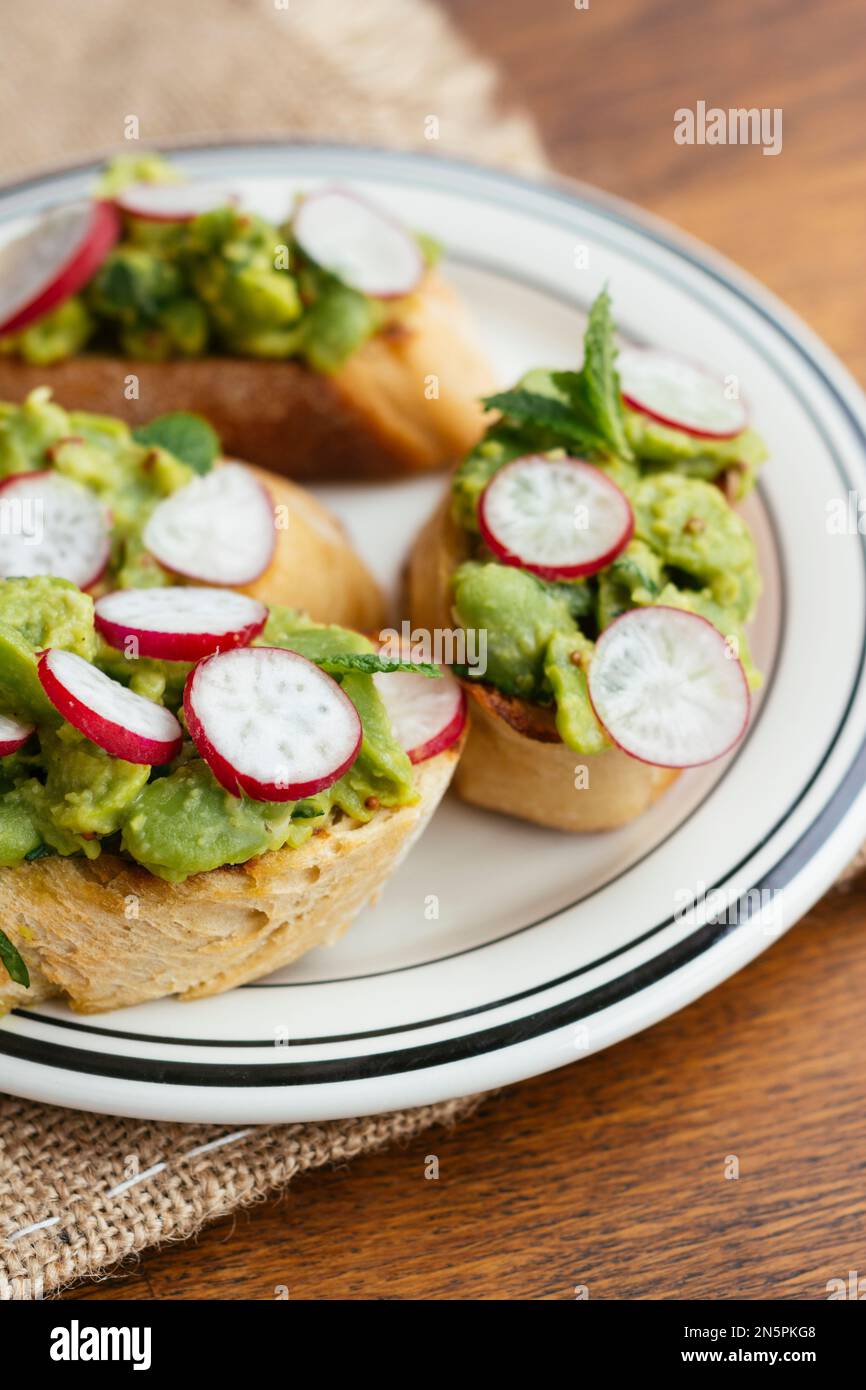 Bruschetta with Fava Beans, Radishes and Mint on a plate Stock Photo