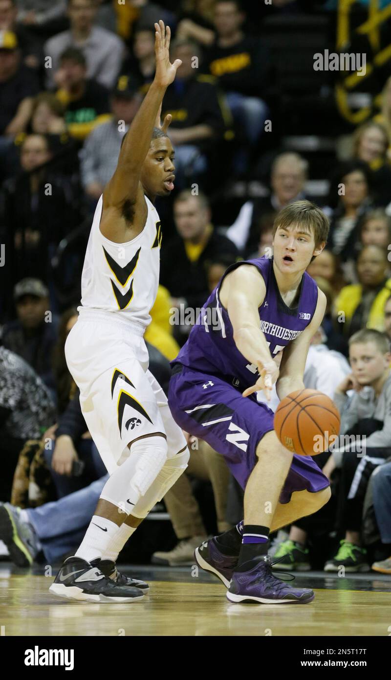 Northwestern forward Kale Abrahamson, right, passes in front of Iowa