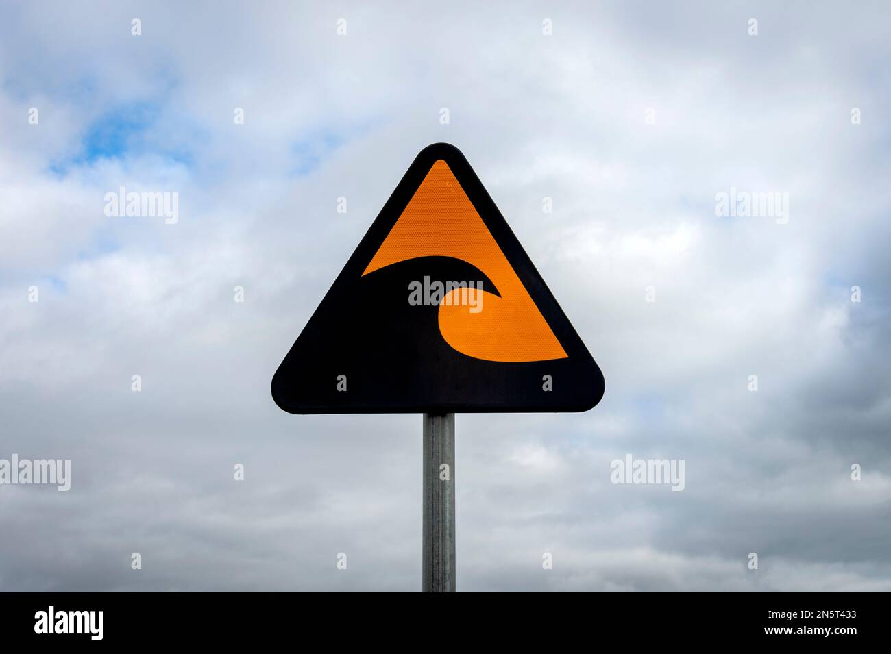 tsunami warning sign against a cloudy sky Stock Photo