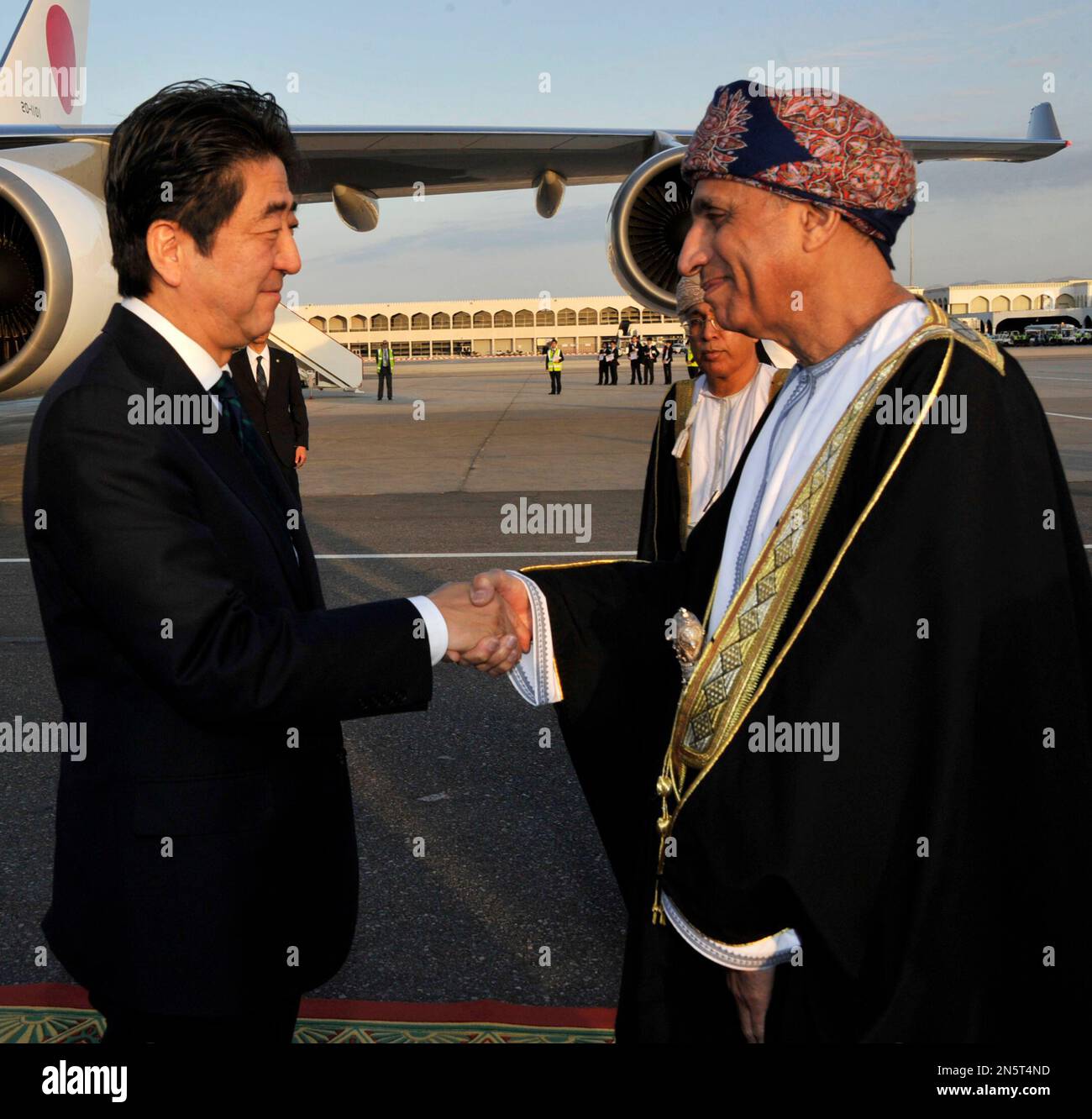 Japanese Prime Minister Shinzo Abe, left, is received by Deputy Prime Minister Sayyid Fahd bin Mahmoud al Saidm during an arrival ceremony in Muscat, Oman on Thursday, Jan. 9, 2013. Abe is on a two day visit to Oman. (AP Photo/Abu Zayed) Stock Photo