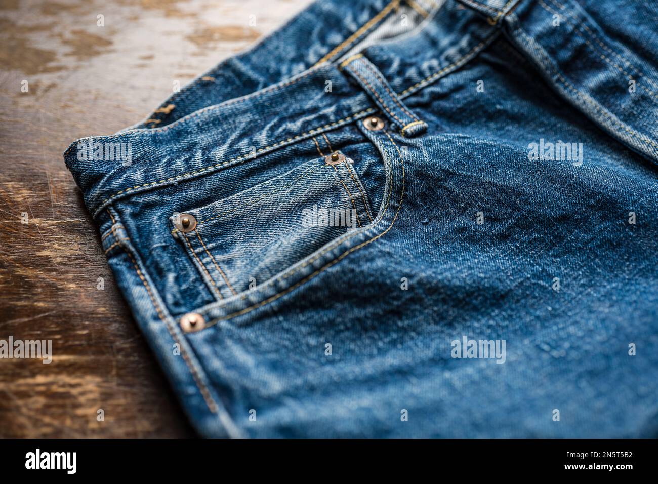 Worn and washed Japanese denim jeans with coin pocket, rivets and