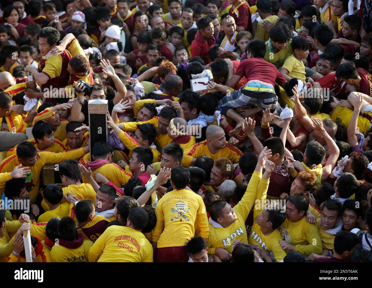 Filipino Catholic devotees reach out to touch the image of the Black ...