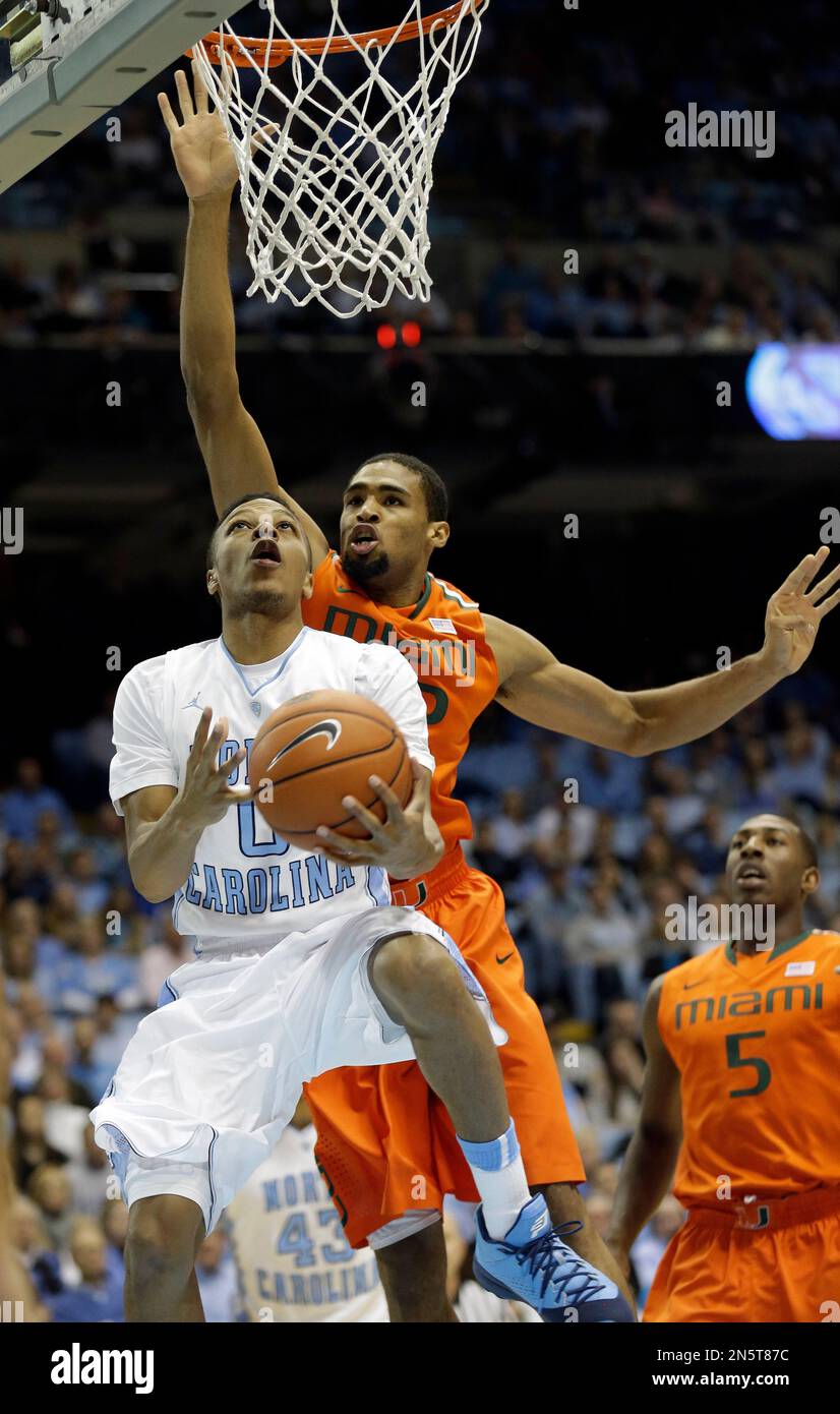 North Carolina's Nate Britt (0) drives to the basket as Miami's