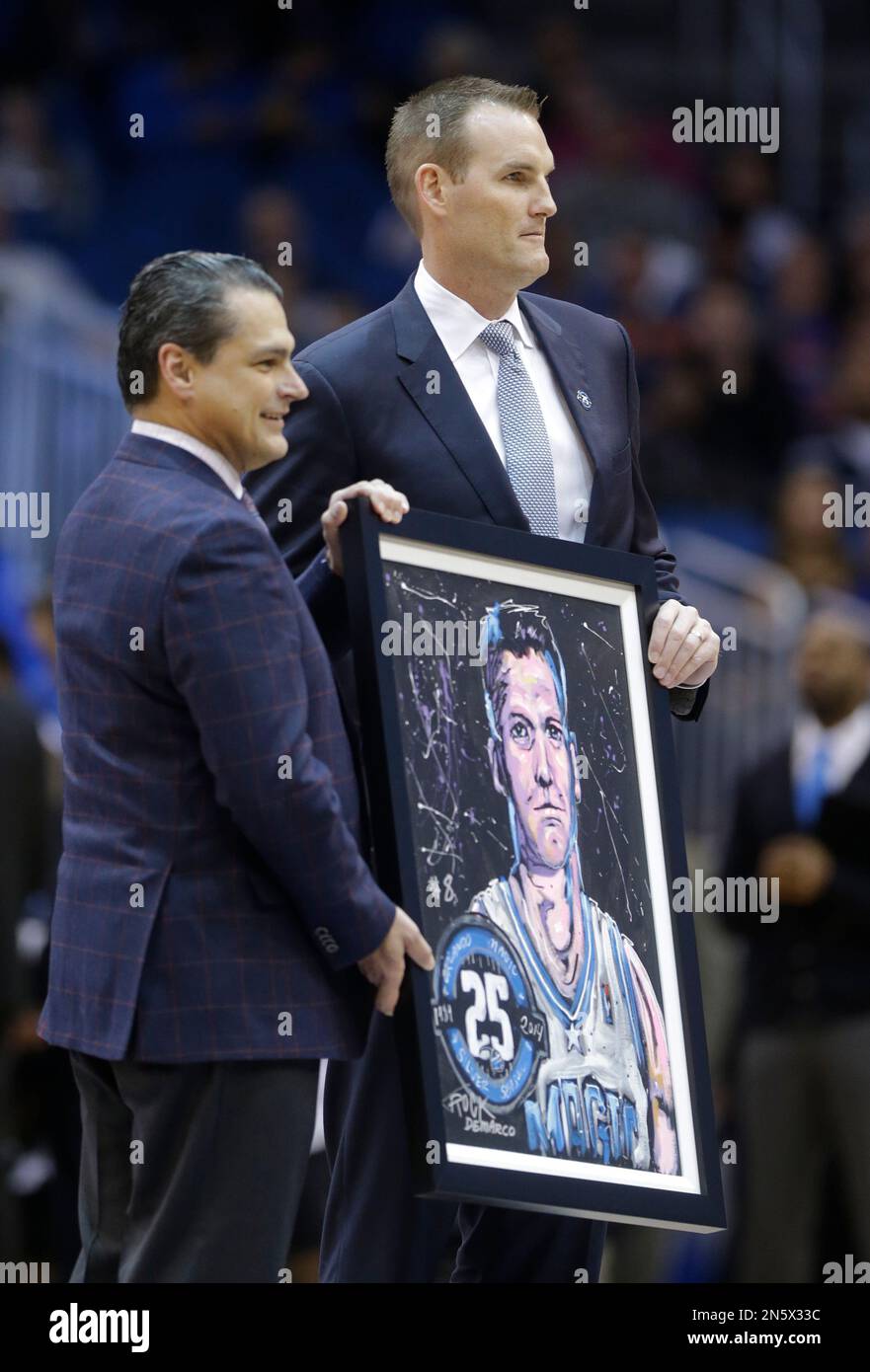 Orlando Magic CEO Alex Martins, left, presents former Magic player Pat  Garrity with a painting to honor him during the first half of an NBA  basketball game against the Detroit Pistons in