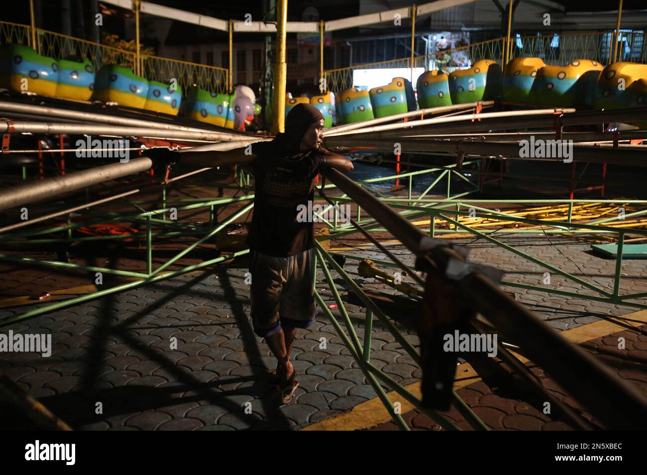 A Filipino worker takes a break from completing an amusement ride at a ...