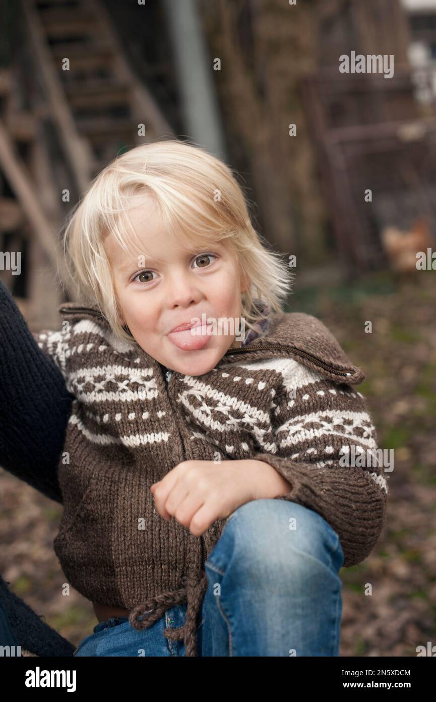 Little boy sticking his tongue out in farm, Bavaria, Germany Stock ...