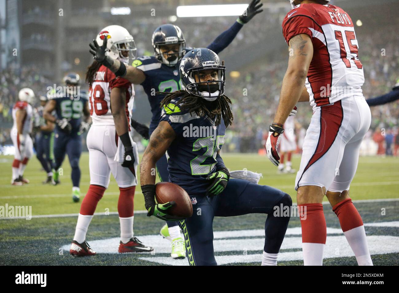 Seattle Seahawks' Richard Sherman, center, gets up after intercepting