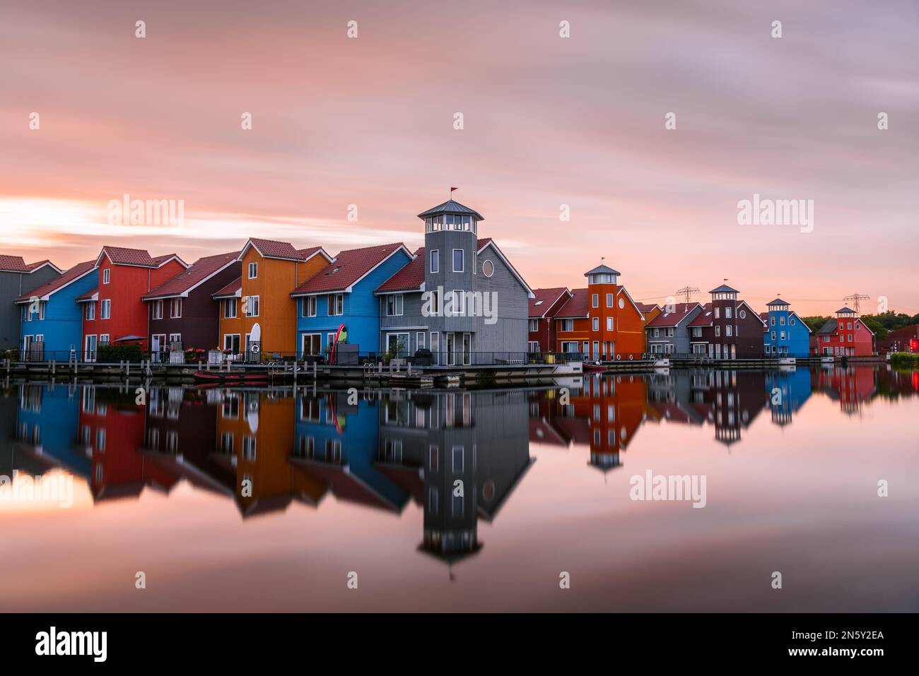 Multicolour harbourside row houses at sunset. Long exposure and reflection in water. Stock Photo
