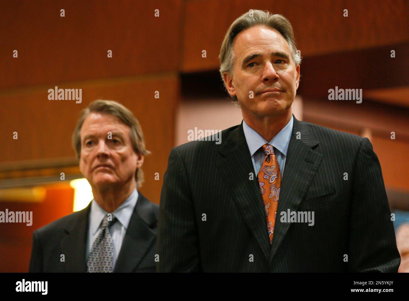 University of Texas athletic director Steve Patterson, right, and school president Bill Powers listen as Mack Brown, announces that he is stepping down as head football coach in Austin, Texas on Sunday, Dec. 15, 2013. The Longhorns have had four straight seasons with at least four losses. Texas went 8-4 this year and Brown's final game will be the Dec. 30 Alamo Bowl against Oregon. (AP Photo/Jack Plunkett) Stock Photo