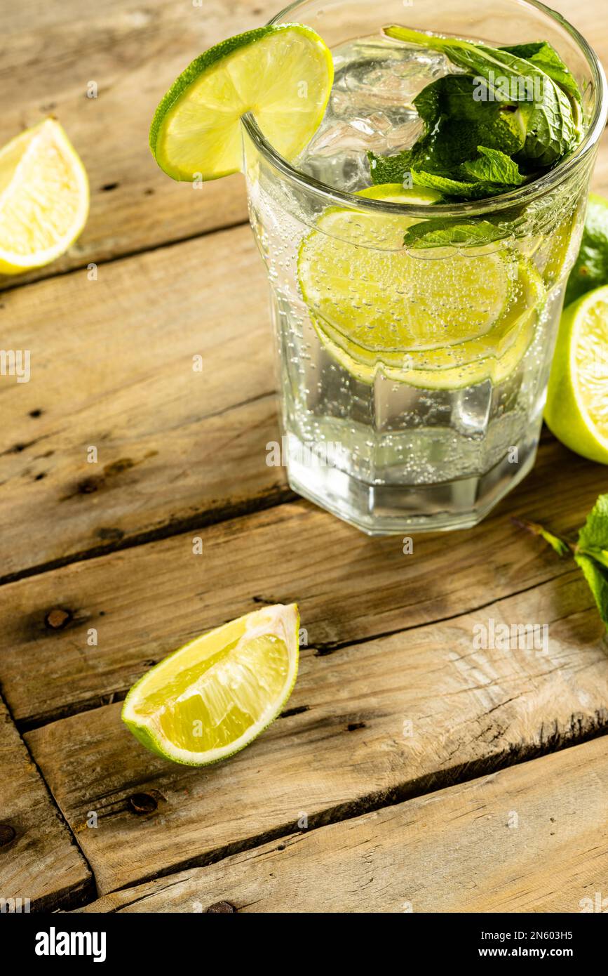 Close up of glass with water and limes with copy space over wooden surface Stock Photo